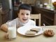 Chłopiec pijący mleko i jedzący śniadanie